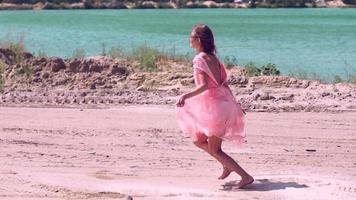 bela jovem de vestido rosa no deserto video