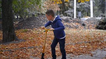 Vorschulkind fährt auf einem Roller im Herbstpark video