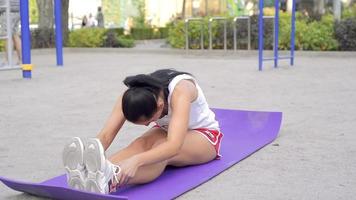 mujer morena caucásica adulta trabajando en abdominales en el gimnasio de la calle en un cálido día de verano video