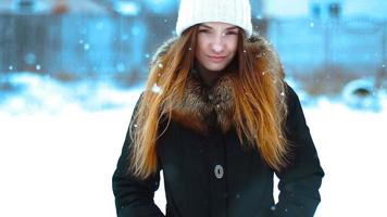 Cutie girl in winter outside in a snowstorm posing