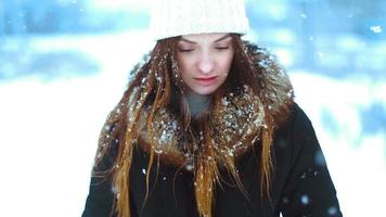 hermosa chica en invierno afuera en una tormenta de nieve posando video