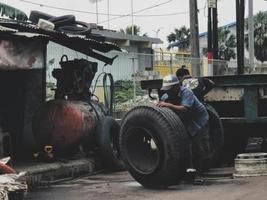 Jakarta, Indonesia in July 2022. Two men were replacing a blown truck tire. photo