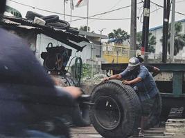 Jakarta, Indonesia in July 2022. Two men were replacing a blown truck tire. photo