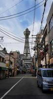 osaka, 8 de abril de 2019. una vista desde una pequeña calle en osaka, donde puedes ver tsutenkaku foto