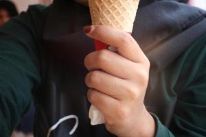 a woman's hand holding an ice cone. photo