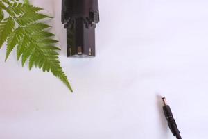 battery and leaves over white background for electric car industry theme. photo