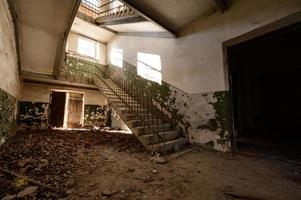 Stairs in an abandoned house, a destroyed industrial building, a house with broken windows. photo