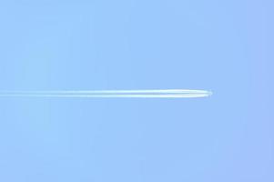 Traces and white streaks from the jet engines in the plane, white stripes in the sky. photo