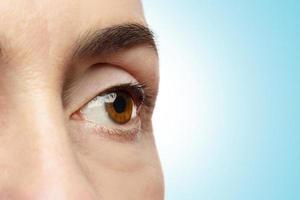 Close-up of female eye on blue background. photo