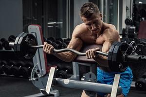 Muscular man during workout in the gym photo