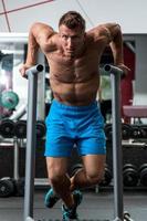 Muscular man during workout in the gym photo