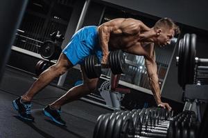 Muscular man during workout in the gym photo