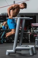 Muscular man during workout in the gym photo