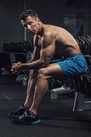 Muscular man during workout in the gym photo