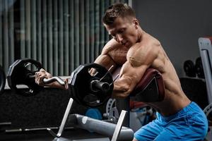 Muscular man during workout in the gym photo