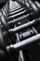 Different black dumbbells in the modern gym photo