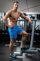 Muscular man during workout in the gym photo