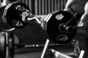 Muscular man during workout in the gym photo