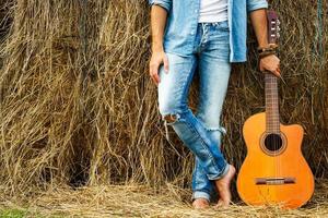 hombre y guitarra acústica al lado del pajar foto