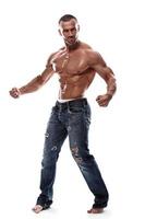 Handsome muscular man wearing jeans posing in studio photo