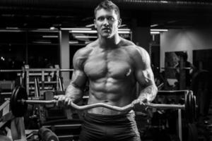 Muscular man with barbell in the gym photo