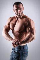 Handsome muscular man wearing jeans posing in studio photo