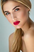 Blonde woman with red lips posing in studio photo