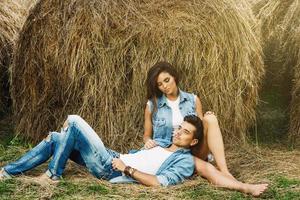 Young lovely couple is relaxing among the haystacks photo