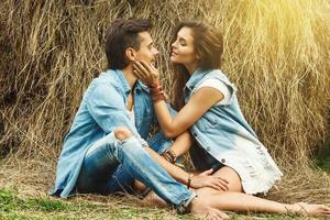 Young lovely couple is relaxing among the haystacks photo