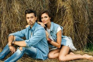 Young lovely couple is relaxing among the haystacks photo