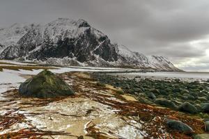 pintoresca playa de guijarros en eggum, islas lofoten, ártico, noruega, escandinavia, europa en un día nublado de invierno. foto