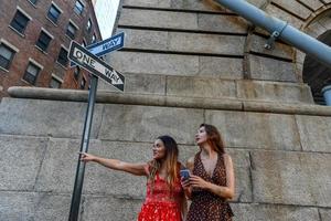 Two lost girls interacting with a mobile phone to get directions in New York City photo