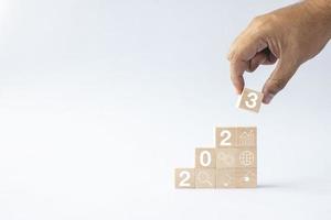 2023 business growing growth concept to success. hand picking woods block step with icon concept about business strategy, Action plan, Goal and target, hand stack, project, vision. photo