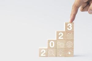 2023 business growing growth concept to success. finger tapping woods block step with icon concept about business strategy, Action plan, Goal and target, hand stack, project, vision. photo