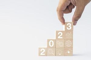 2023 business growing growth concept to success. hand picking woods block step with icon concept about business strategy, Action plan, Goal and target, hand stack, project, vision. photo