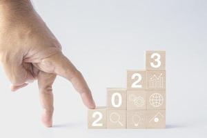 2023 business growing growth concept to success. fingers are going up woods block step with icon concept about business strategy, Action plan, Goal and target, hand stack, project, vision. photo