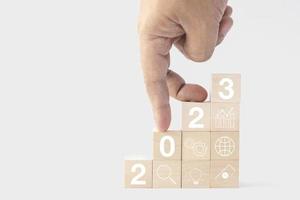 2023 business growing growth concept to success. fingers are walking down woods block step with icon concept about business strategy, Action plan, Goal and target, hand stack, project, vision. photo