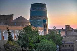 Kalta Minor Minaret and the historic architecture of Itchan Kala, walled inner town of the city of Khiva, Uzbekistan a UNESCO World Heritage Site. photo