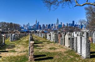 New York City - Feb 23, 2020 -   Calvary Cemetery with Manhattan skyline in New York. Calvary Cemetery is a cemetery in Queens, containing more than 3 million burials. photo