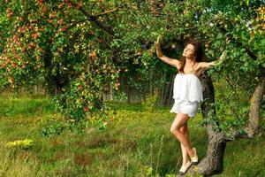 Beautiful woman and apple tree in the garden photo