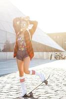 Stylish girl with a skateboard on the street photo