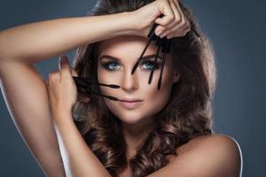 Beautiful woman applying mascara on her lashes photo