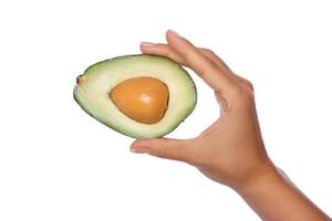 Hand with fresh avocado fruit on white background photo