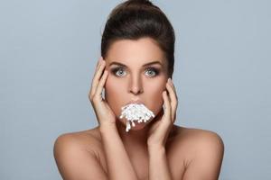 Young woman with a full mouth of cotton swabs photo