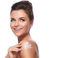 Young beautiful woman with cream on her shoulder photo