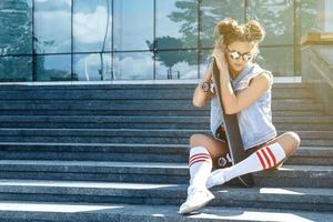 chica elegante con patineta en la calle foto