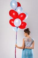 Woman wearing beautiful dress with a lot of colorful balloons photo
