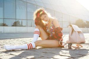 Stylish girl with a skateboard on the street photo