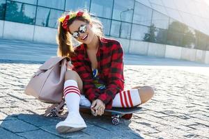 Stylish girl with a skateboard on the street photo