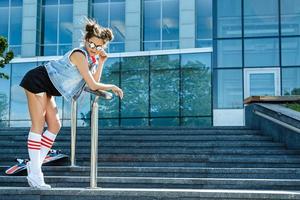 Stylish girl with a skateboard on the street photo